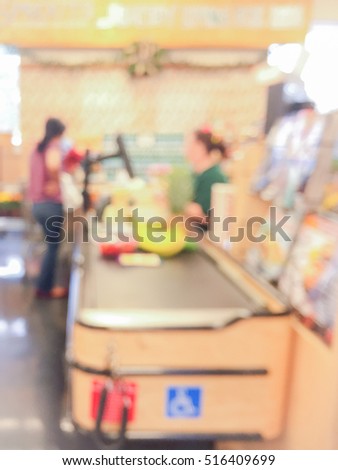 Blur image cashier with a customer at check-out counter.  Cashier register, computer, checkout payment terminal. Background picture.