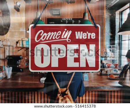 A business sign that says 'Come in We're Open' on Cafe / Restaurant window.