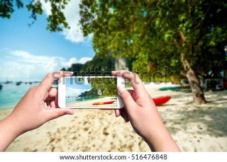 woman hands holding mobile phone at beach