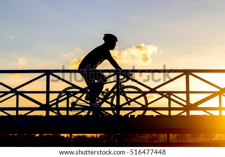 silhouette biker riding bicycle on the bridge in sunset