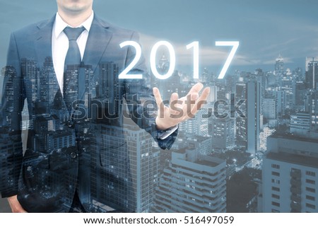 Double expoure of professional businessman showing welcome celebrate new years 2017 on hand for business and happy new year concept