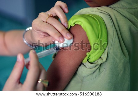 Vaccinating A Child,Injection with a syringe to prevent flu. Royalty-Free Stock Photo #516500188