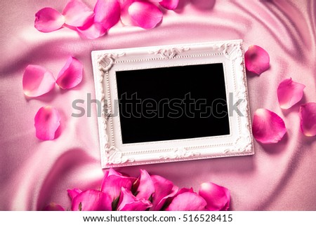 Empty photo frame with a bouquet sweet pink roses  petal on  soft pink silk fabric , romance and love card concept
