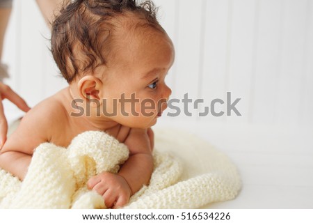Newborn baby on stomach looking aside, free space on white. Adorable little child interested of something. Background for children care and development products