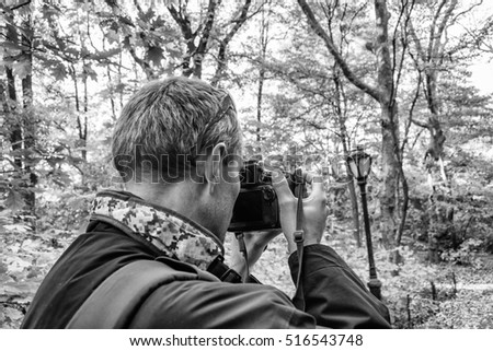 Photographer in Central Park capturing foliage, New York City.
