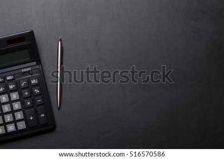 Office leather desk table with calculator and pen. Top view with copy space Royalty-Free Stock Photo #516570586