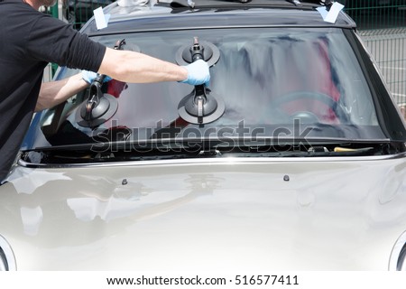 Glazier removing windshield on a car Royalty-Free Stock Photo #516577411