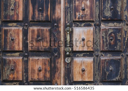 ancient wooden door with the brass handle close up