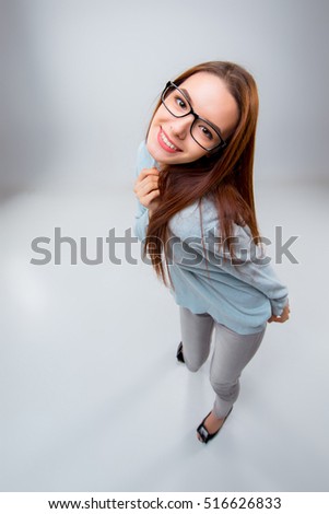 The smiling young business woman on gray background