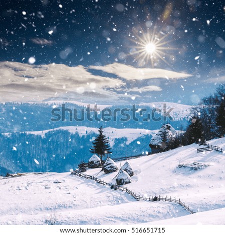 Winter landscape with cottages and hay bales in rural landscape. Christmas concept