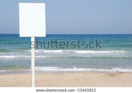 A Blank white Sign on a pole by the Sea side