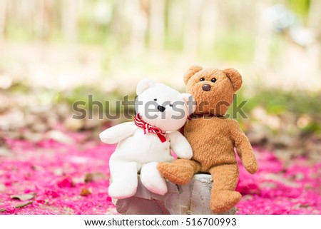 lovely teddy brown and white bear sitting at pink nature background.