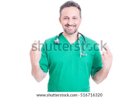 Cheerful medic showing fingers crossed with both hands and smiling on white background