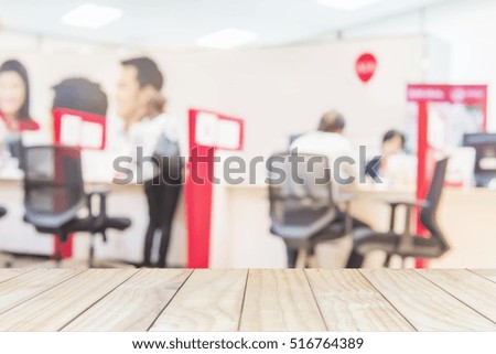 White wooden table top over blurred business customer service room with some of people 