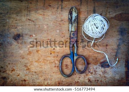 Old scissors and a ball of twine on the old background, Top view with copy space