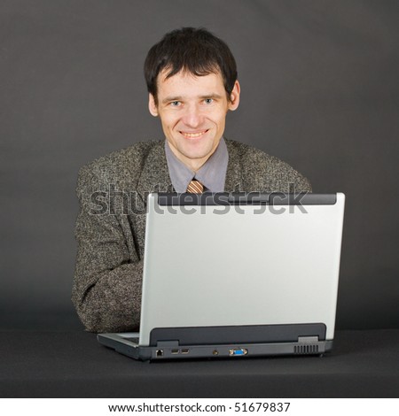 A young man with a computer on a dark background