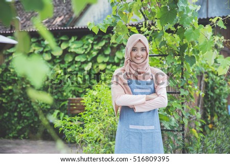 proud cafe owner standing and smiing to camera in front of her coffee shop Royalty-Free Stock Photo #516809395