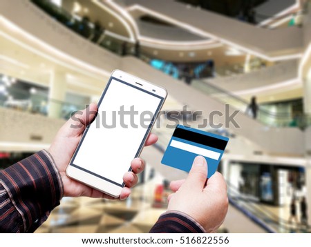 Hand Hold Smart phone with Credit Card over blurred of  Shopping mall. blurry backgrounds