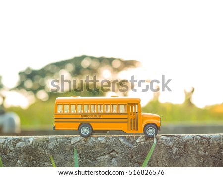 yellow school bus plastic and metal toy model on the country road
