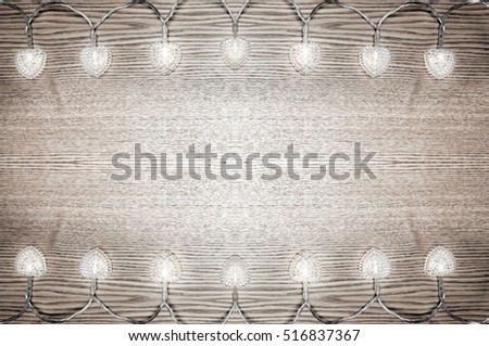 Christmas background. Christmas lights on a light wooden background. Xmas background.