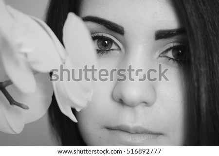 portrait of model who sniffs orchid