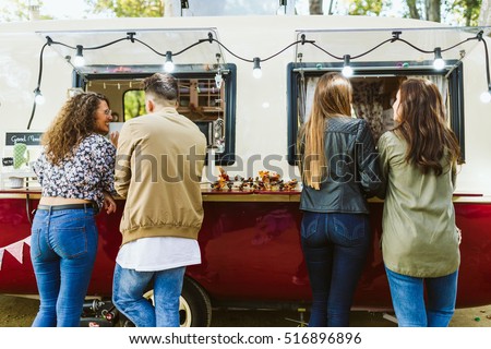 Portrait of group of friends visiting eat market in the street. Royalty-Free Stock Photo #516896896