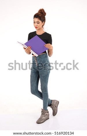 Attractive young female student carrying books on white background