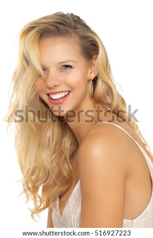 Beautiful smiling girl with long blond hair on beige background.