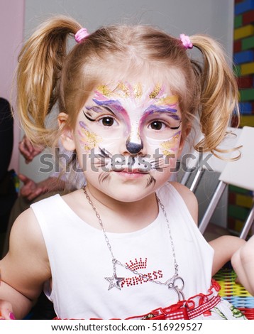 little cute blonde girl with faceart on birthday party having fu
