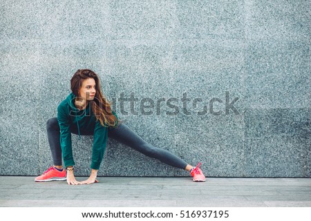 Fitness sport girl in fashion sportswear doing yoga fitness exercise in the street, outdoor sports, urban style Royalty-Free Stock Photo #516937195