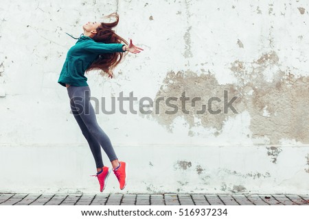 Fitness sport girl in fashion sportswear dancing hip hop in the street, outdoor sports, urban style Royalty-Free Stock Photo #516937234