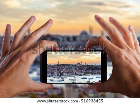 Travel concept. Hand making photo of night city with smartphone camera. Istanbul. Turkey