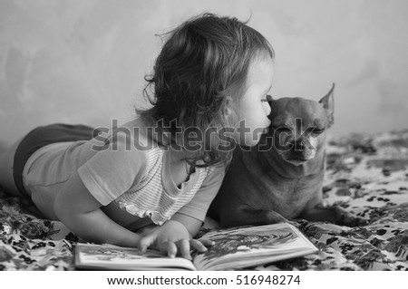 girl teach dog to read the book)) Royalty-Free Stock Photo #516948274