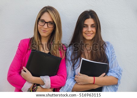 Young businesswomen with folders with documents in their arms.