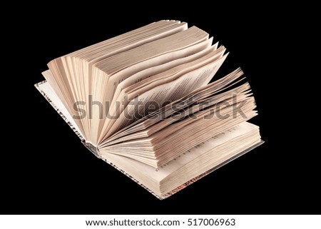 High contrast light on an open antique bible with black background and good copy space