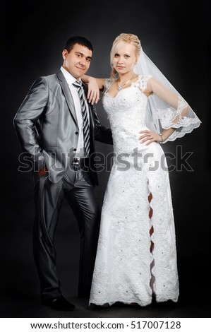 Loving newlyweds standing on a gray background