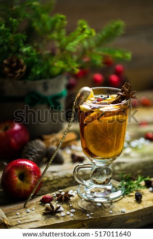 Glass of hot christmas drink with orange, apples, cinnamon stick, anise and cloves