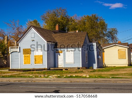Abandoned Home With Boarded Up Doors & Windows Royalty-Free Stock Photo #517058668