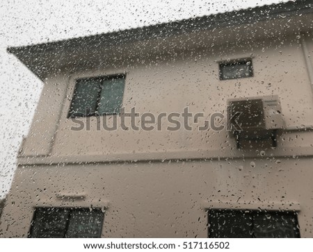 Raindrops at glass, home blurred background