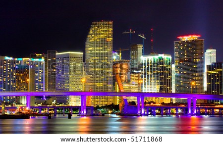 Colorful night view of city of Miami Florida with downtown buildings in the financial business district and Biscayne bridge bridge