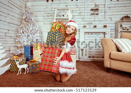 Closeup portrait surprised young beautiful excited happy girl wearing red santa claus hat costume looking shocked by lot of gifts