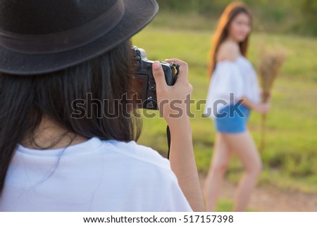 Young woman photographer shoot model. Photography in action.