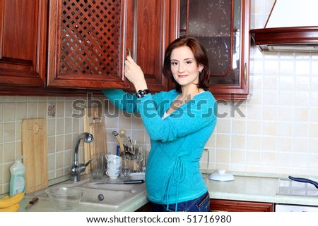 Young pregnant woman cooking meals at home.