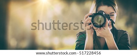 Portrait of a photographer covering her face with the camera. Royalty-Free Stock Photo #517228456