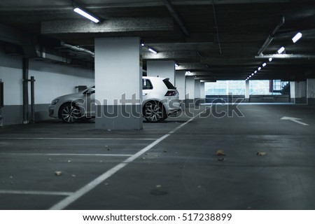 White car parked in empty parking garage. Royalty-Free Stock Photo #517238899