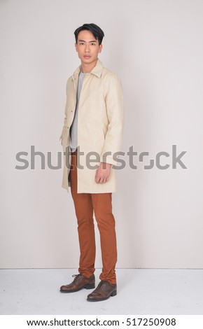 Full body fashion Shot of a young man in coat. He is now a professional