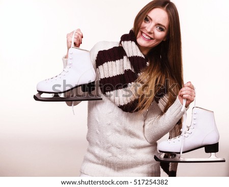 Winter skate sport people concept. Attractive girl with ice skates. Young woman has white outfit and long beutiful hair.