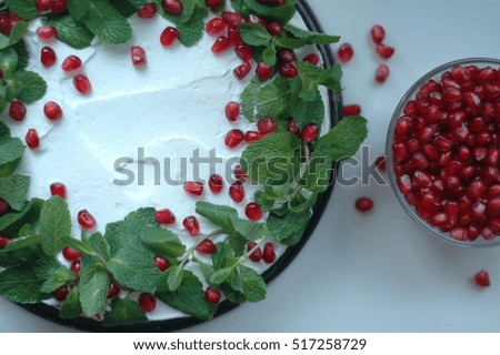 Sponge cake with white cream, mint and berries pomegranate.