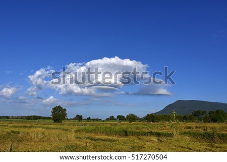 lenticular wind cloud resembling a UFO flying saucer over  mountain in countryside , thailand  Royalty-Free Stock Photo #517270504