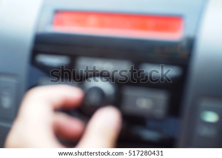 Blurred  background abstract and can be illustration to article of hand adjusting the sound volume in the car stereo